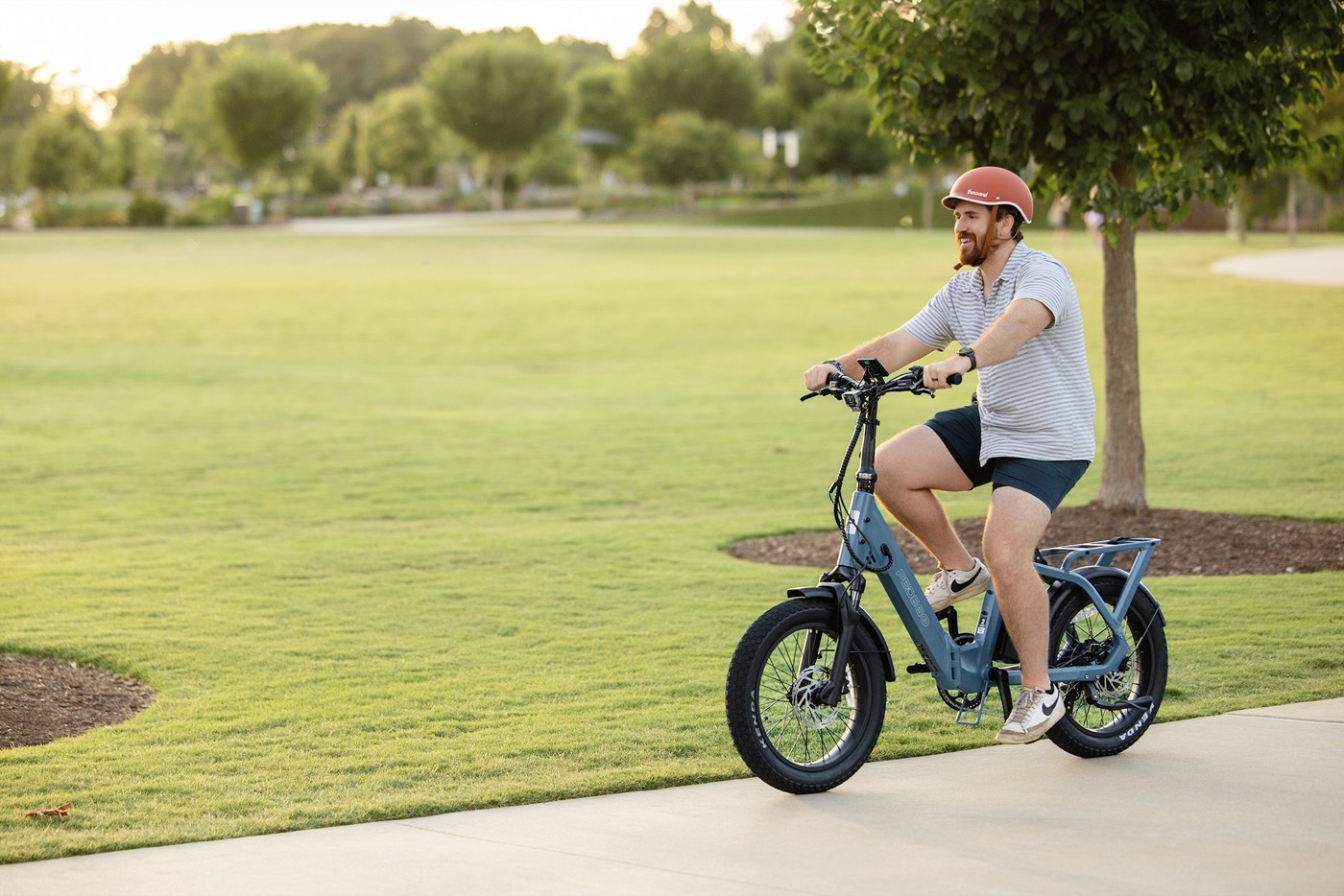 A rider on a Pedego Latch 2 folding e-bike on a park path