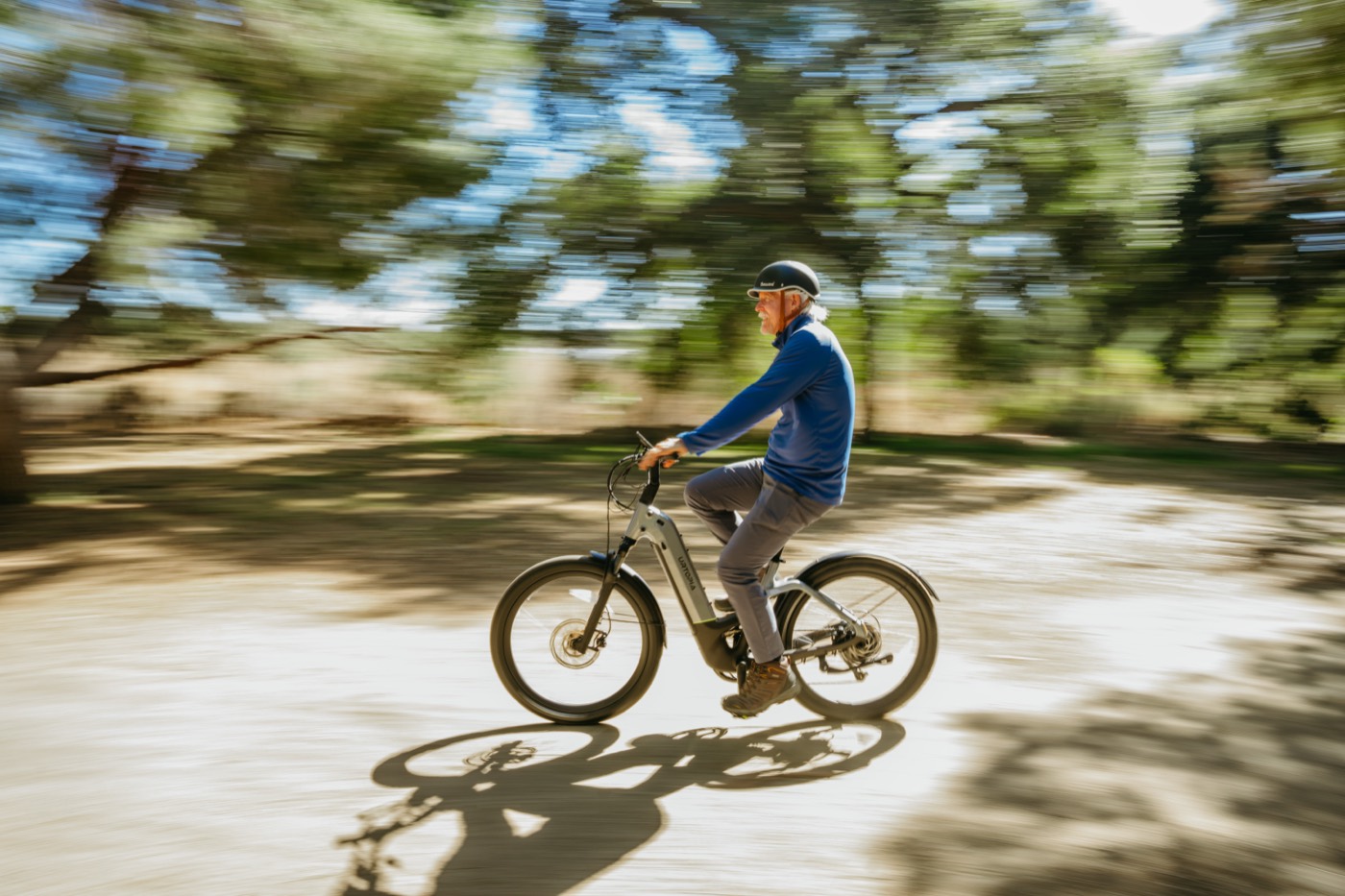 A rider moving at speed on an Urtopia Atom, the background blurred